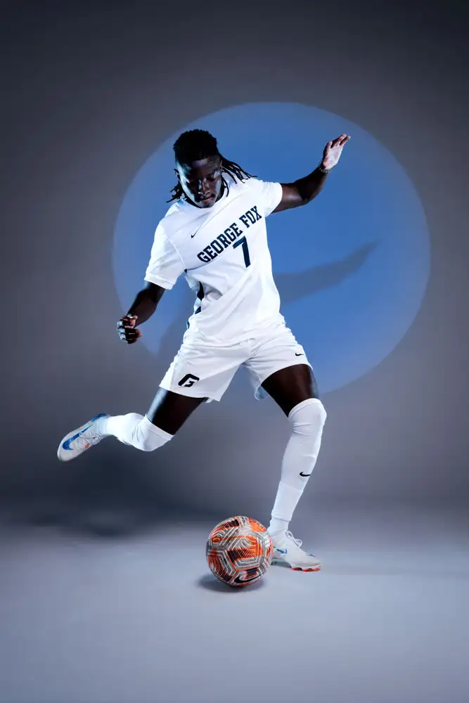 George Fox soccer athlete about to kick a ball