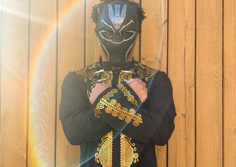 Espero dresssed as Black Panther, his arms crossed across his chest