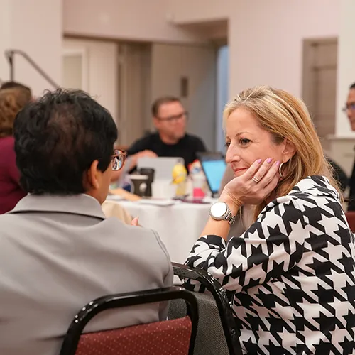 Jennifer having a conversation with someone at a table