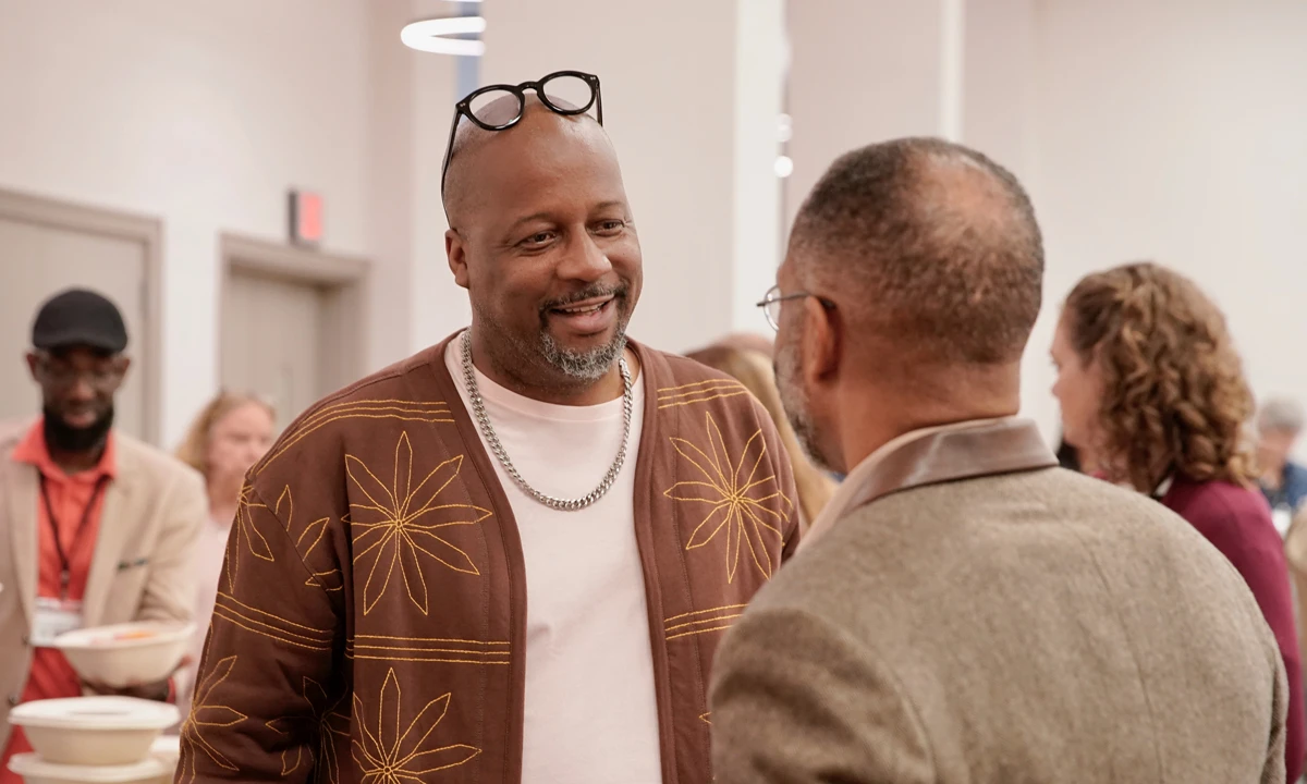 Daren Jaime at a gathering smiling softly in conversation