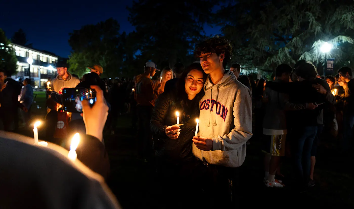A mother holds her son during the candlelight goodbye