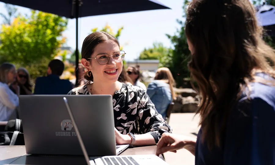 Students laughing and talking while working outside