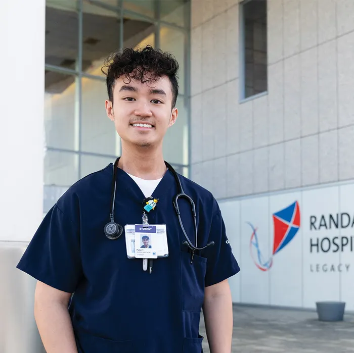 Peter Tran stands in front of his hospital