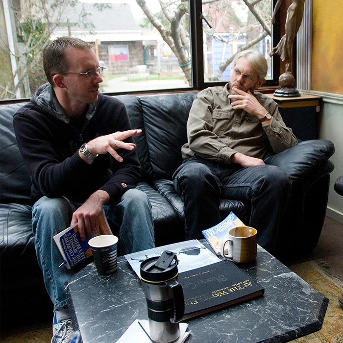 Two men talking on a couch