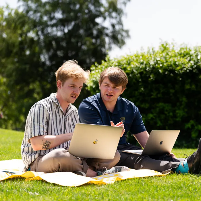 Students on laptops on the quad