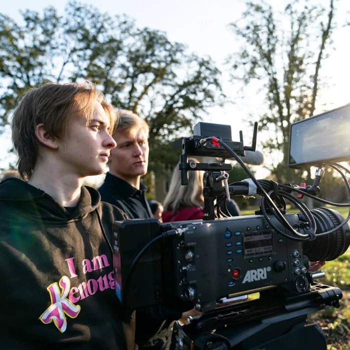 Cinematic arts students adjusting a camera