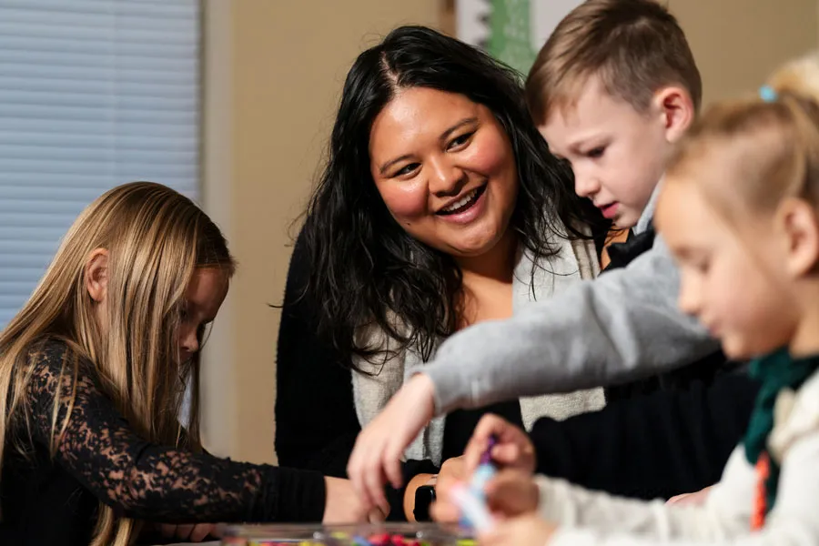 Teacher smiles at students while they work