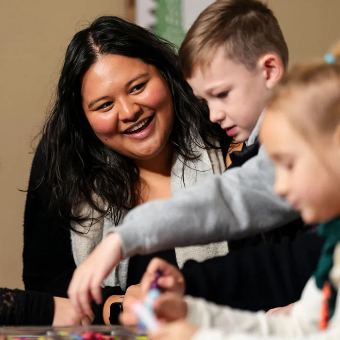 teacher smiles while children play