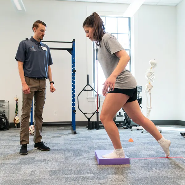 DPT student works with an athlete in a gym