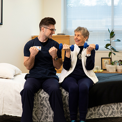 Student helping older patient with exercises